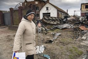 A woman with a wheelbarrow near the destroyed Russian equipment in Gostomel