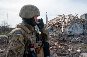 The fighter of the territorial defense near the houses destroyed as a result of shelling in Chuguev
