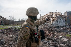 The fighter of the territorial defense near the houses destroyed as a result of shelling in Chuguev