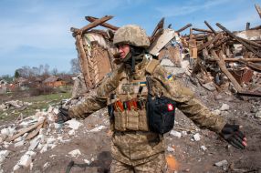 The fighter of the territorial defense near the houses destroyed as a result of shelling in Chuguev