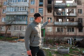 A man walks near a ruined house in Kharkiv