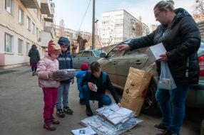 A woman walks with children in Kharkiv