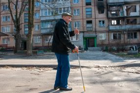 A man walks near a ruined house in Kharkiv
