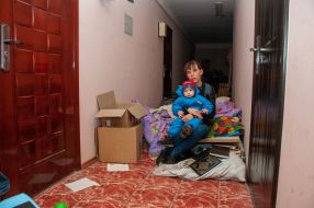 A woman with a child hiding in the hallway of a house in Kharkiv