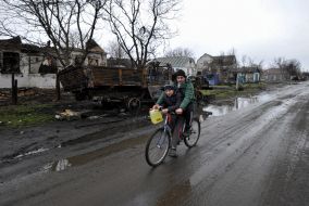 A man and a boy ride a bicycle in Andriyivka