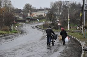 A woman and her husband are carrying bags in Andriyivka
