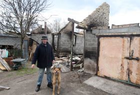 Man with a dog near the ruined house
