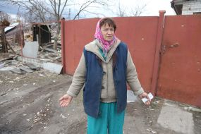 Жінка біля зруйнованого будинку