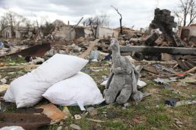 Іграшка на зруйнованому в результаті обстрілів російськими військами подвір'ї