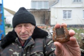 The man shows a fragment of a shell