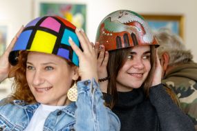 Visitors try on painted steel helmets