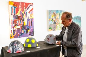 The visitor examines the painted steel helmets