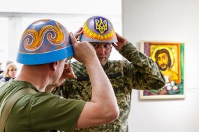 Visitors try on painted steel helmets