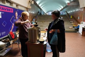A volunteer distributes food at the metro station "Constitution Square" in Kharkiv