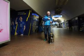 Man with a dog at the metro station "Constitution Square" in Kharkiv