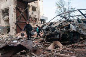 People walk down the street in Kharkiv destroyed after the Russian R-500 "Caliber" missile hit