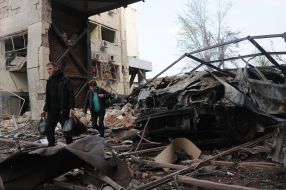 People walk down the street in Kharkiv destroyed after the Russian R-500 "Caliber" missile hit