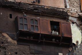 Kitchen cabinet with a ceramic rooster on the wall of a residential building in Borodyanka destroyed by shelling