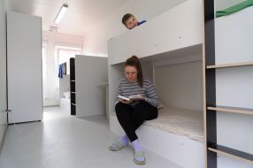 A girl reads a book in a modular house in Lviv