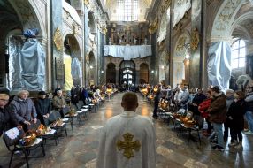 The priest is blessing the easter baskets in Lviv
