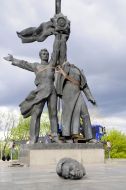 The head of a Russian worker near the bronze sculpture of two workers under the arch of friendship of peoples in Kiev