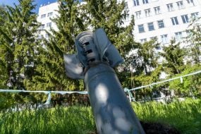 A Smerch MLRS shell sticks out in the ground in front of a district clinic in the city of Chuguev