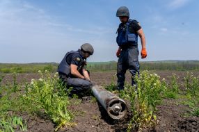 Employees of the State Emergency Service remove cluster munition from the ground in a field in Kharkiv region
