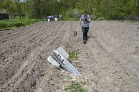 Чоловік з лопатою біля снаряду на полі в Чернігівській області