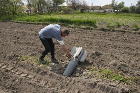 A man near a shell on a field in the Chernihiv region