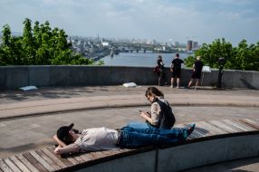 People are resting on the observation deck near the Arch of Friendship of Peoples