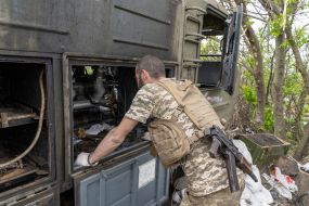 Ukrainian soldier inspects damaged Russian military equipment