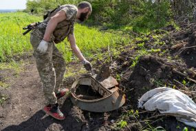 Ukrainian soldier inspects the remains of Russian military equipment