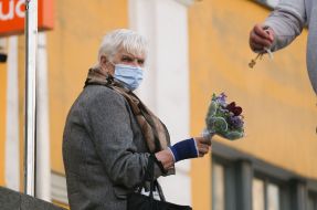 Elderly woman sells flowers on the street