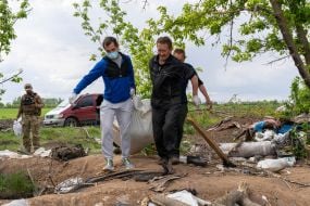 Volunteers carry the exhumed corpses of Russian soldiers in the Kharkiv region