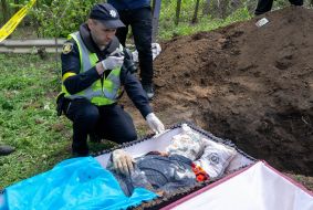 The expert conducts investigative actions during the exhumation of the body of a murdered resident of the village of Koropove