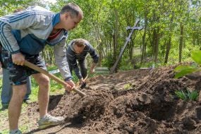 Volunteers dig a grave during the exhumation of the body of a murdered resident of the village of Koropove