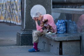 An elderly woman is resting in the center of Kiev