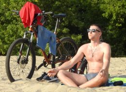 Молода людина засмагає на пляжі