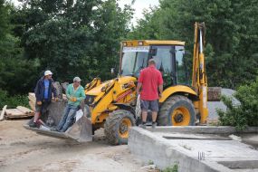 Workers near the excavator on a construction site in Lviv