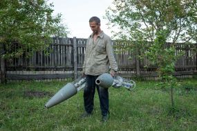 Oleksandr Shepelyuk, a resident of Rakivka village, demonstrates rockets