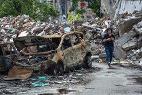 Burned car near the destroyed houses