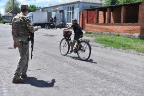 А boy on a bicycle rides near the Ukrainian military