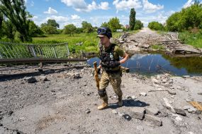 Украинский солдат возле разрушенного моста