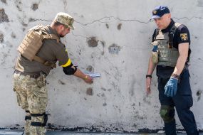 Прокурор и эксперт-взрывотехник проводят расследование на крыше дома