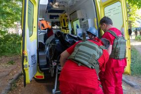 Медики забирають тіло вбитого чоловіка після обстрілу