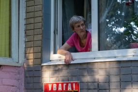 Жінка виглядає з вікна будинку