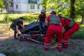 Медики забирають тіло вбитого чоловіка після обстрілу