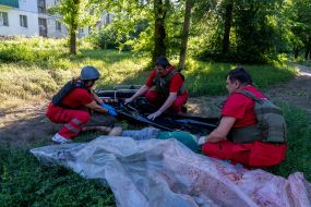 Медики забирають тіло вбитого чоловіка після обстрілу