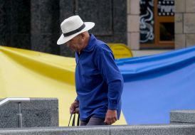 A man walks near the flag of Ukraine in Kyiv