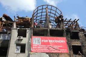 Men collect scrap metal in a house destroyed by the Russian occupiers in Irpen